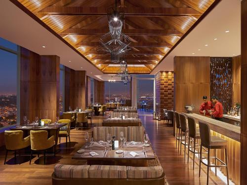 a restaurant with tables and chairs and a bar at Shangri-La Bengaluru in Bengaluru