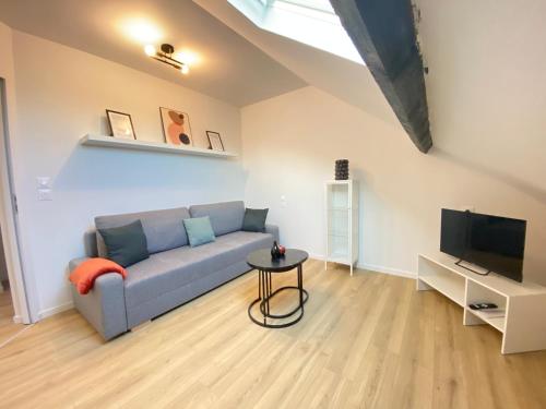 un salon avec un canapé bleu et une télévision dans l'établissement Appt 4 couchages Jardin Laverie Parking, à Dunkerque