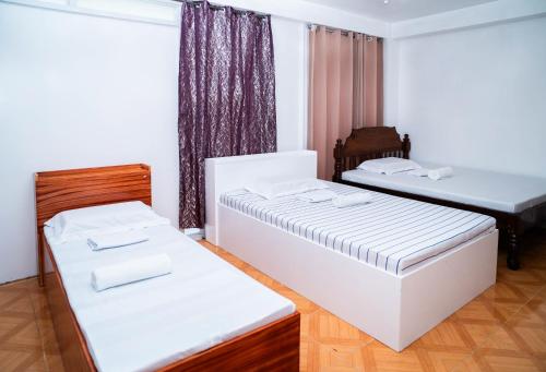 a room with two beds and a window at RedDoorz at Lao Singuan Homestay in Del Carmen