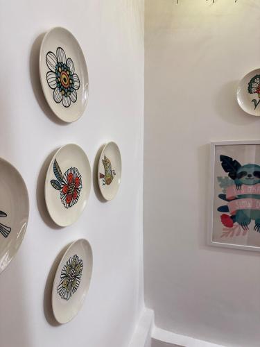 a wall with plates on a white wall at Abode 3-2 bhk attic private terrace Siolim Marna in Camorlim
