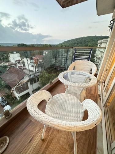 a balcony with two wicker chairs and a table at Abode 3-2 bhk attic private terrace Siolim Marna in Camorlim