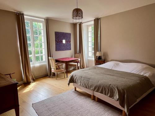 une chambre avec un lit, une table et des chaises dans l'établissement Maison de famille vallée de Chevreuse, à Saint-Forget