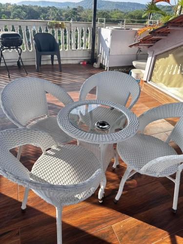 a patio with four chairs and a table on a deck at Abode 3-2 bhk attic private terrace Siolim Marna in Camorlim