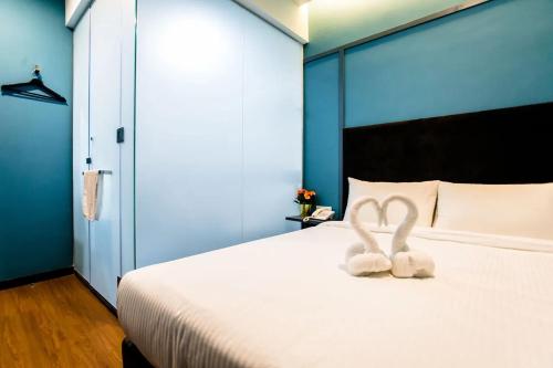 a bedroom with a bed with two stuffed animals on it at Jenjarom Boutique Hotel in Banting