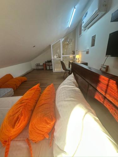 a bedroom with two beds with orange pillows on them at Abode 3-2 bhk attic private terrace Siolim Marna in Camorlim