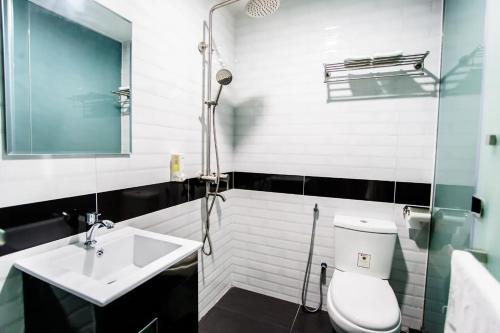 a bathroom with a toilet and a sink and a shower at Jenjarom Boutique Hotel in Banting