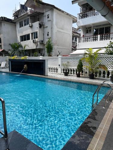 a large blue swimming pool in front of a building at Abode 3-2 bhk attic private terrace Siolim Marna in Camorlim