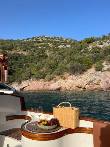 a table with a basket of fruit and wine glasses on a boat at Yazz Collective in Fethiye