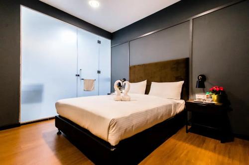 a bedroom with a large bed and a large window at Jenjarom Boutique Hotel in Banting