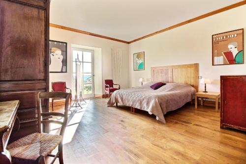 une chambre avec un lit, une table et des chaises dans l'établissement Luxury villa in Domme: Pool and Breathtaking View, à Domme