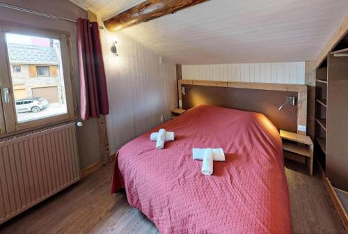 een slaapkamer met een bed met twee handdoeken erop bij Chalet De Manou - Chalet individuel rénové avec sauna dans les 3 Vallées MAE-3694 in Saint-Martin-de-Belleville