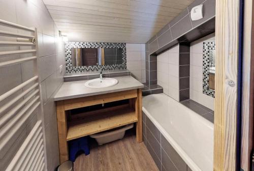 een kleine badkamer met een wastafel en een bad bij Chalet De Manou - Chalet individuel rénové avec sauna dans les 3 Vallées MAE-3694 in Saint-Martin-de-Belleville