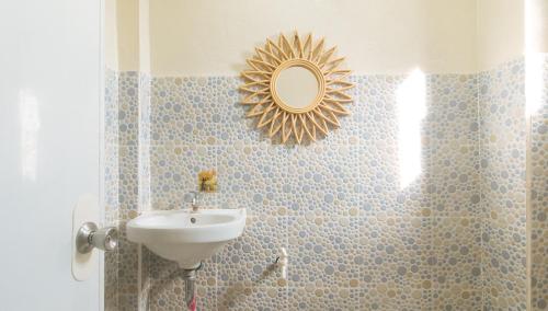 a bathroom with a sink and a mirror on the wall at Bello Vue Apartelle in Old Pandanon
