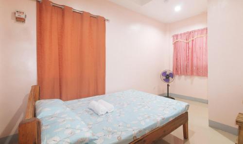a bedroom with a bed and a window at Bello Vue Apartelle in Old Pandanon