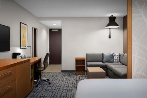 a room with a bed and a couch and a desk at Hyatt Place Boulder Pearl Street - Newly Renovated in Boulder