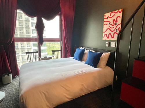 a bedroom with a bed with blue pillows and a window at Blue Ocean Hotel 4 in Incheon