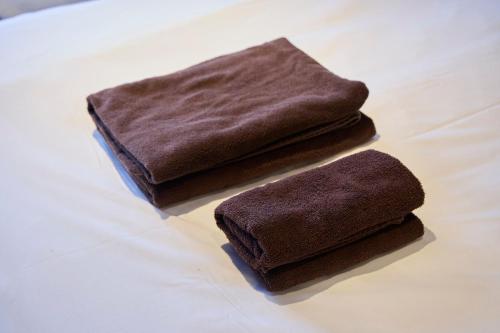 two brown towels sitting on top of a table at OPUS Haneda in Tokyo