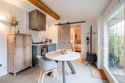 a small kitchen with a white table and chairs at Rustig Tiny House in het groen nabij Enschede & UT in Enschede
