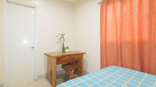 a bedroom with a bed and a wooden table at Bello Vue Apartelle in Old Pandanon