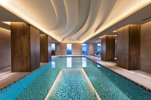 a swimming pool in a hotel with a ceiling at DoubleTree by Hilton Osaka Castle in Osaka