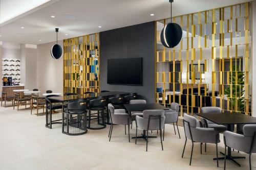 a restaurant with tables and chairs and a flat screen tv at Homewood Suites By Hilton Raleigh Downtown in Raleigh
