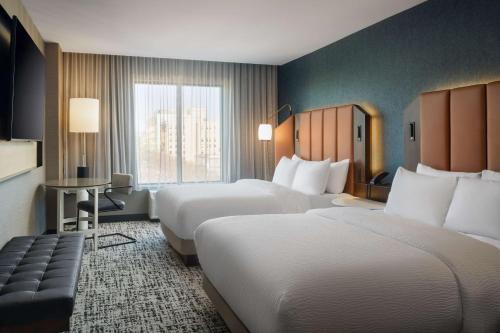 a hotel room with two beds and a window at Tempo By Hilton Raleigh Downtown in Raleigh