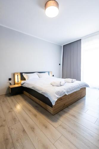 a bedroom with a large bed and a wooden floor at Bella Mare Boutique apartment in Sunny Beach