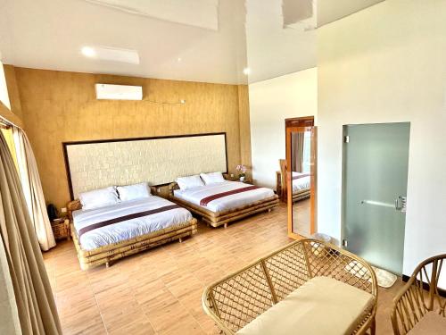 a bedroom with two beds and a chair in it at Bayview Beach Resort East Lombok in Labuan Lombok