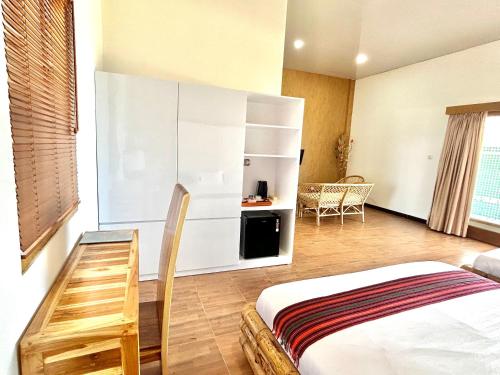 a bedroom with a bed and a table and a kitchen at Bayview Beach Resort East Lombok in Labuan Lombok