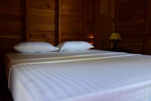 a large white bed with two pillows on it at Wilpattu Tree House in Wilpattu