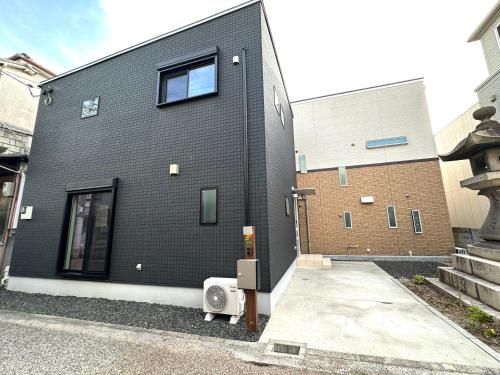 a black brick building with a window at Koguma新大阪燈燈苑 in Osaka