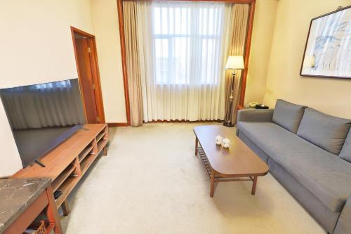 a living room with a couch and a table at Jianguo Qianmen Beijing in Beijing