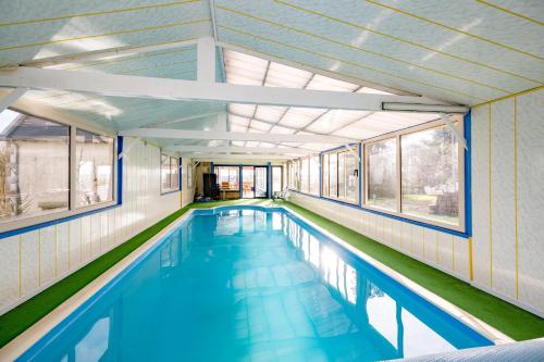 - une piscine dans un bâtiment avec fenêtres dans l'établissement La Picardière - Piscine intérieure à Erquy, à Erquy