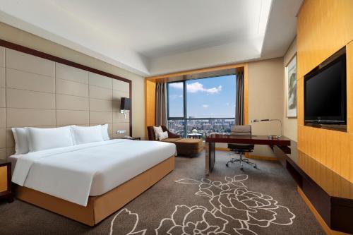 a bedroom with a bed and a desk and a television at Crowne Plaza Yichang by IHG in Yichang