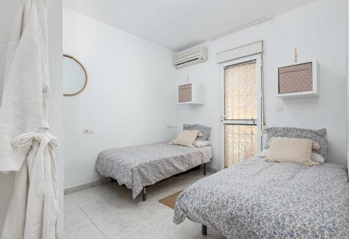 een slaapkamer met twee bedden en een raam bij Casa Fre - Lomas Del Golf - Villamartin in Villamartin