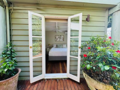 a room with a bed through a door at Misty Valley Cottage in Mapleton