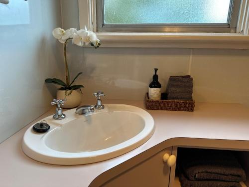 a white sink in a bathroom with a window at Growse House 2BR in Yarram