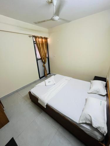 a bedroom with a large white bed with a window at REGAL SUITES in Trivandrum