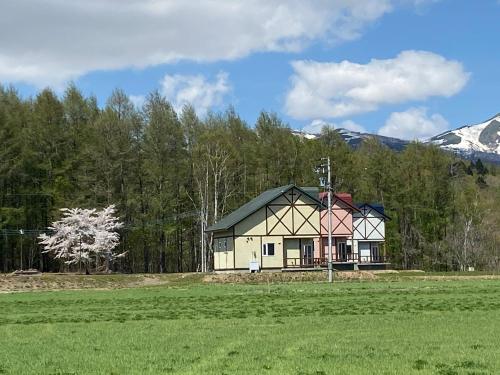 a small house in the middle of a field at ふれあいの郷ひので in Rankoshi
