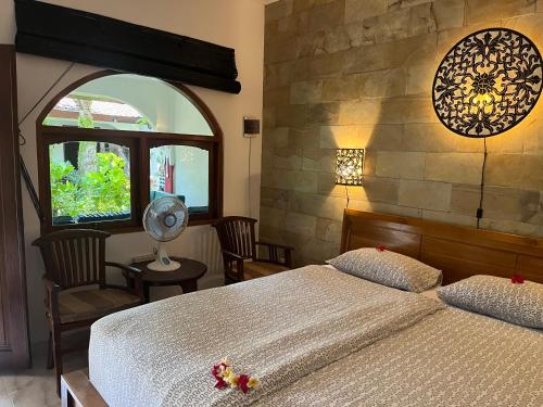 a bedroom with a large bed and a window at Catra homestay beach apartments in Candidasa