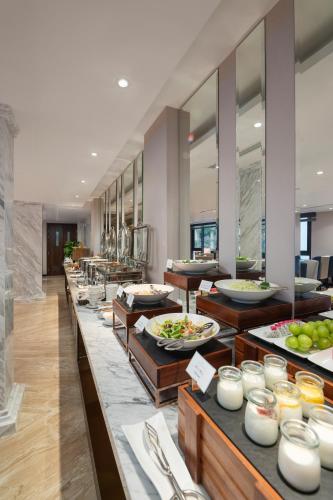 a buffet line with plates of food on display at SEN BOUTIQUE HOTEL - Managed by SEN HOTEL GROUP in Hanoi