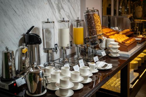 a buffet with cups and cups on a table at SEN BOUTIQUE HOTEL - Managed by SEN HOTEL GROUP in Hanoi