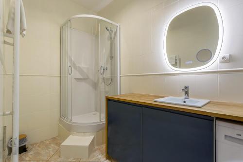 une salle de bain avec un lavabo et une douche avec un miroir dans l'établissement Smartstay Chill republique - Villeurbanne, à Villeurbanne