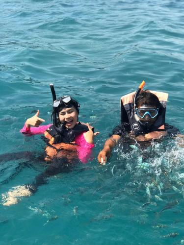 two people in the water in the ocean at Manee Poolvilla in Khanom
