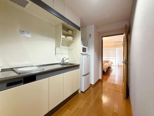 a kitchen with a sink and a refrigerator at Grandeur - Secure & Stylish 1BR Calm Stay Near Downtown in Hiroshima