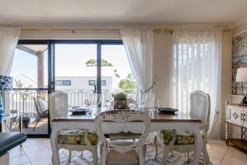 a white dining room with a table and chairs at Champagne Skies - In Town Upstairs Apartment in Margaret River Town