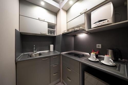 a small kitchen with a sink and a stove at Bellevue Park Hotel Riga with FREE Parking in Rīga