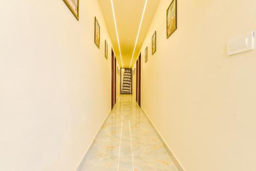 a long hallway with a tile floor and white walls at FabHotel Blooming Beds Pearl in Jaipur