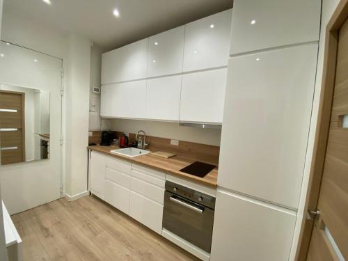 une cuisine avec des armoires blanches et un évier dans l'établissement Appartement Nice 2 chambre 2 lits 1 salle de bain, à Nice