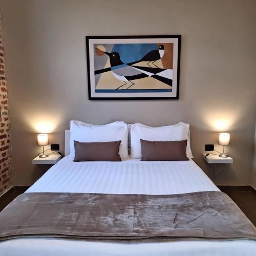 a bedroom with a large white bed with two lamps at Cascina Mora Bassa in Vigevano